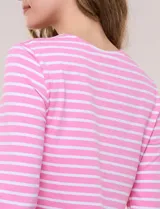 Remera semi entallada de algodón con elastano, con estampado de rayas horizontales blancas y rosadas, escote bote y mangas tres cuartos de corte raglán.