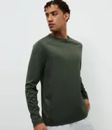 Remera deportiva de manga larga con cuello redondo, confeccionada en tejido técnico Dry Fit. Presenta un diseño liso con sutiles detalles reflectantes en los hombros.