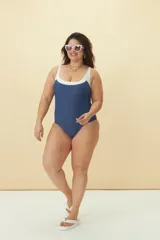 Malla enteriza de diseño bicolor, con cuerpo en color azul y detalle de escote y breteles en color blanco. Presenta un corte clásico con escote redondo.