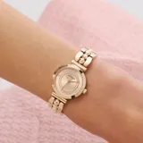 Reloj analógico Guess modelo Leena con caja de 27mm en tono oro rosa. La esfera presenta un diseño minimalista con un anillo interior decorado con cristales. La correa es de acero inoxidable en tono oro rosa con un diseño tipo brazalete de eslabones esféricos.