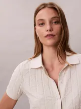 Chomba Calvin Klein de manga corta en color blanco, con cuello clásico, cierre frontal con botones y diseño de jacquard con estampado integral.