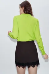 Falda pantalón de tiro alto confeccionada en tejido satinado, con detalle de puntilla en el ruedo. Cuenta con forro interior y cierre lateral con cremallera oculta.