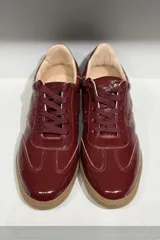 Championes de cuero vacuno con acabado brillante tipo charol, color azul marino, con cordones al tono y suela de goma color caramelo.