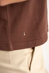 Remera de algodón negro con mangas cortas abullonadas, cuello redondo y costura central frontal.