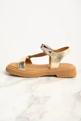 Sandalia de cuero color dorado con tiras marrón y estampado animal print, con plataforma marrón.