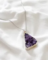 Collar con cadena de acero plateado y dije de amatista natural en bruto con borde plateado.