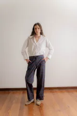 Pantalón de corte relajado con estampado de cuadros escoceses en tonos azul, verde y bordó. Presenta cintura elástica en la parte posterior, cordón de ajuste frontal y terminación en el ruedo con detalle de frunce ajustable.