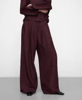 Pantalón bordó de pierna ancha, confeccionado en mezcla de viscosa y lino, con cinturilla elástica en la espalda, doble pinza en el delantero y bolsillos laterales.