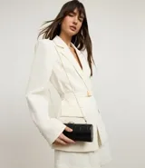 Cartera baguette color negro con textura crocco y correa de cadena fina.