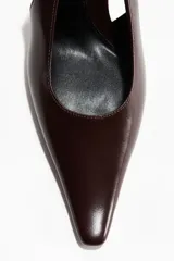 Zapatos de tacón destalonados en color marrón oscuro, con diseño de punta fina y tira elástica en el talón.