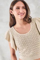 Top de punto calado color beige con brillo metalizado, escote redondo y mangas cortas con volados.