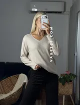 Sweater de punto color bordó con escote en V y detalle de strass aplicado en la parte frontal. Presenta mangas largas y corte holgado.