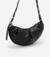 Cartera tipo shoulder bag de diseño media luna, confeccionada en poliuretano con acabado brillante. Presenta detalles frontales estilo gota, cierre superior por cremallera y correa de hombro ajustable con ojetes metálicos.