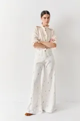 Pantalon de corte wide leg y tiro alto, color rosado con estampado de motivos deportivos como pelotas de fútbol y raquetas de tenis. Cuenta con cierre frontal con botón y bolsillos laterales.
