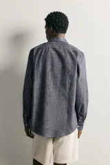 Camisa de corte regular fit confeccionada en tejido de algodón, con cuello solapa, manga larga con puños abotonados, bolsillo plastrón en el pecho y cierre frontal de botones.