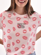 Remera de manga corta con estampado camuflado en tonos verdes, marrones y blancos. Cuenta con cuello redondo y ribetes en color rosado, además de un delicado bordado central con la palabra "XOXO" en tono rosado a juego.