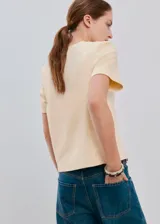 Camiseta de manga corta y cuello redondo color amarillo claro, confeccionada en algodón con ribete elastizado en el cuello.