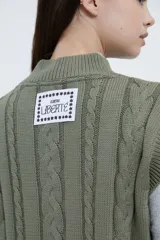 Chaleco tejido color verde oliva con cuello en V y diseño de trenzas.