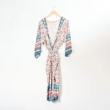 Kimono largo con estampado floral en tonos naranja, azul y blanco, con mangas anchas y lazo en la cintura.