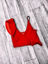 Top de bikini fucsia con un solo tirante y volados en el escote.