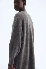 Saco largo de punto fino color gris oscuro, con lana en la trama. Diseño sin cierre, con hombros caídos y ribete acanalado en nuca, puños y bajo.