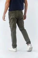 Pantalón cargo de hombre con fit slim, confeccionado en una mezcla de algodón y elastano. Presenta cierre de cremallera y botón, bolsillos laterales tipo cargo, pasa cinto y terminación con puños elásticos en los tobillos.