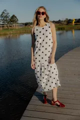 Vestido midi blanco con lunares negros, sin mangas y corte holgado.