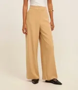 Pantalón wide leg color marrón claro, de tiro alto, con cierre tradicional y doble botón en la cintura.