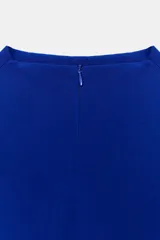Vestido midi de color azul eléctrico con cuello subido y diseño sin mangas. Presenta un cuerpo liso y una falda con caída fluida y detalle de tul en el bajo.