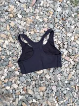 Top deportivo negro con espalda tipo nadadora y breteles anchos.