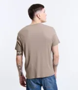 Remera muscle de hombre, color marrón claro, confeccionada en media malla, de cuello redondo y manga corta.