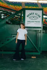 Pantalón Oxford negro de lycra gruesa, con corte acampanado, tiro medio y tajos laterales.