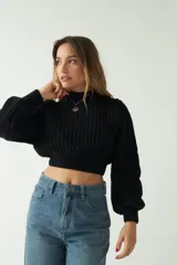 Sweater tejido de punto grueso color crema, con textura chunky, corte cropped, mangas abullonadas y puños ajustados.