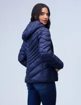 Campera de abrigo verde esmeralda, marca Michael Kors. Diseño acolchado con cierre metálico central, capucha no desmontable con cordón de ajuste y bolsillos verticales delanteros. Incluye bolsa autoportante.