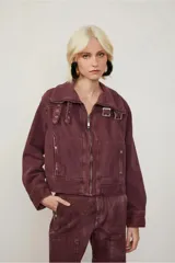 Chaqueta color borgoña de corte recto con cierre frontal metálico y cuello amplio con hebillas decorativas. Cuenta con bolsillos laterales con broches y costuras marcadas que aportan un aire utilitario.