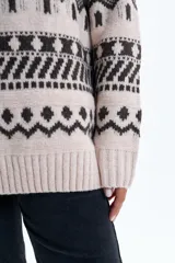 Buzo de punto con diseño de jacquard geométrico en tonos beige y marrón oscuro, cuello redondo y puños acanalados.