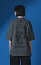 Remera de manga corta con cuello redondo y calce oversize, color gris oscuro. Presenta una estampa frontal con diseño gráfico de un escorpión y una rosa, junto con texto tipográfico.
