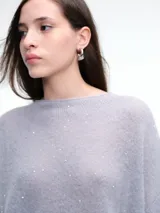 Sweater de punto negro con lentejuelas sutiles, de corte holgado, hombros caídos y mangas largas con terminación acampanada.