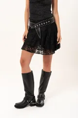 Pollera corta de encaje negro con diseño de vuelos y movimiento ligero, ideal para un look romántico y elegante.