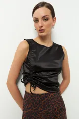 Top sin mangas de satén color gris topo, con cuello redondo y cordones laterales para fruncir.