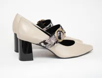 Zapato tipo stiletto con tira sobre el empeine, confeccionado en cuero color arena con detalle de tira en estampado de reptil y hebilla dorada. Cuenta con tacón bloque de altura media en color negro brillante.