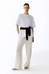 Pantalón de corte holgado en tejido liviano de mezcla de lino. Modelo de tiro alto con cintura elástica y cordón para ajustar fino, bolsillos laterales discretos y piernas rectas.