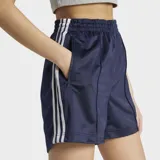 Short Adidas modelo Firebird de corte holgado, color azul marino con las icónicas tres tiras blancas laterales y logo del trébol bordado. Cuenta con cintura elástica y bolsillos laterales con cierre.