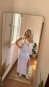 Vestido largo blanco de lino con abertura lateral en la falda. El corpiño es tipo bralette con escote en V y tirantes anchos que se cruzan en la espalda.