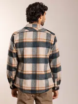 Camisa de franela a cuadros en tonos beige, gris y marrón, con corte regular fit, cuello clásico, cierre de botones frontales y dos bolsillos con solapa en el pecho.