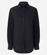 Camisa básica de mujer confeccionada en tricolina de algodón, con cuello solapa, cierre frontal de botones y mangas largas con puños abotonados.