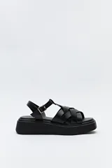 Sandalia negra con plataforma bicolor y capellada de tiras entrelazadas con textura símil reptil. Tiene hebilla metálica lateral para ajustar el calce y suela de goma.