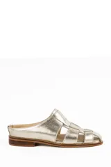 Zueco artesanal de cuero color dorado, con diseño tipo huarache de tiras entrelazadas, punta redonda y suela plana con pequeño tacón.