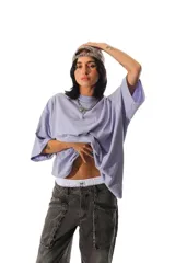 Remerón de corte oversize color lila, con mangas cortas caídas y cuello redondo. Presenta estampados en el frente y en la espalda.