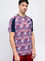 Remera de fútbol Umbro del Club Nacional de Football, modelo Pro Training Active. Diseño con estampado abstracto en blanco, rojo y azul, con mangas raglán azul marino y escudo del club en el pecho.